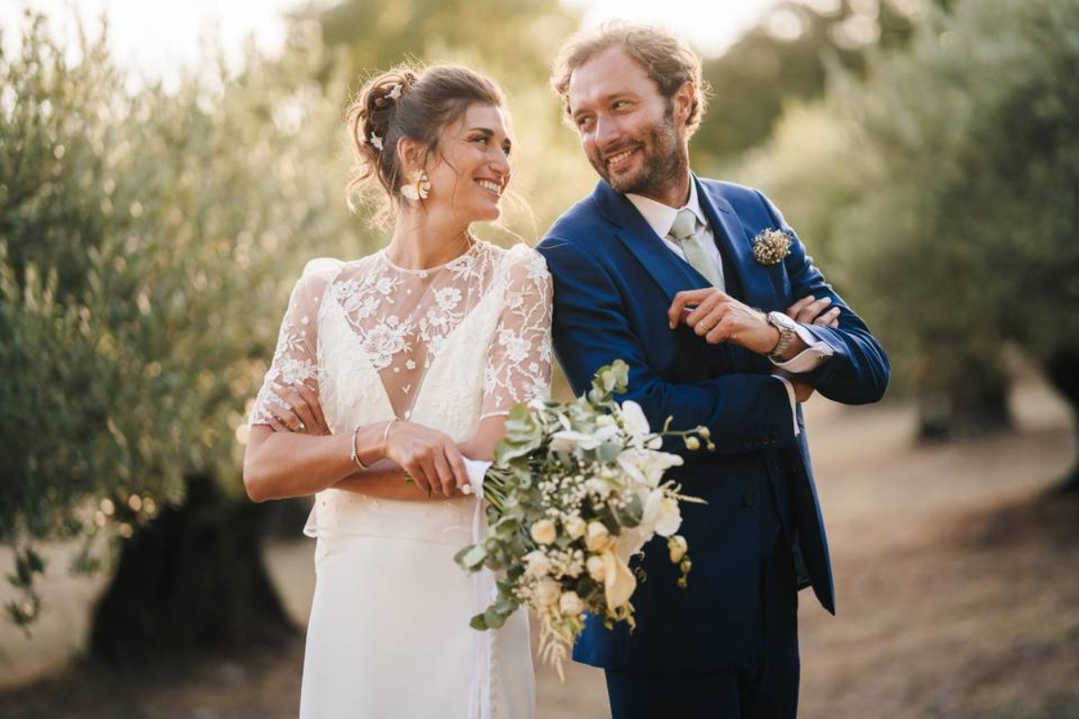 Couple marié souriant, célébrant leur anniversaire de mariage en extérieur, symbole d’amour complice et de noces de mariage durables.